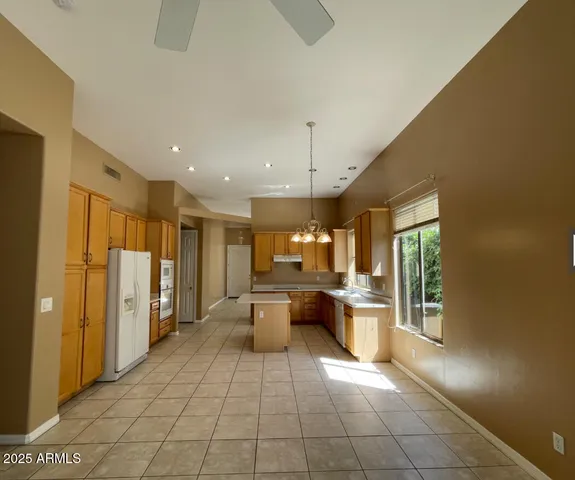 a large white kitchen with a large window and stainless steel appliances