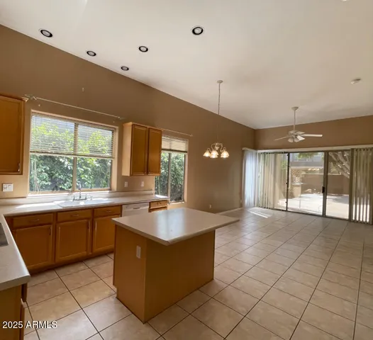 a large kitchen with kitchen island granite countertop a large window