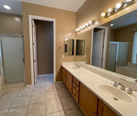 a spacious bathroom with a double vanity sink mirror and shower