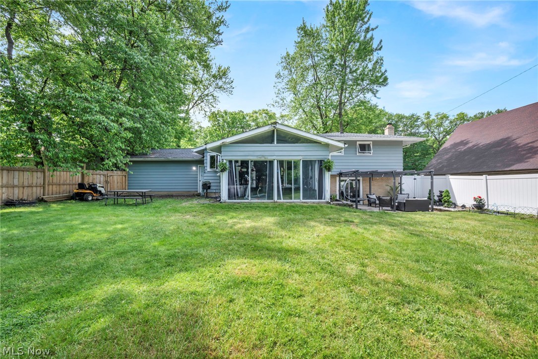 12956 Huffman Road Parma, OH 44130 - Photo 36 of 49 Rear view of property featuring a patio area, a sunroom, and a lawn