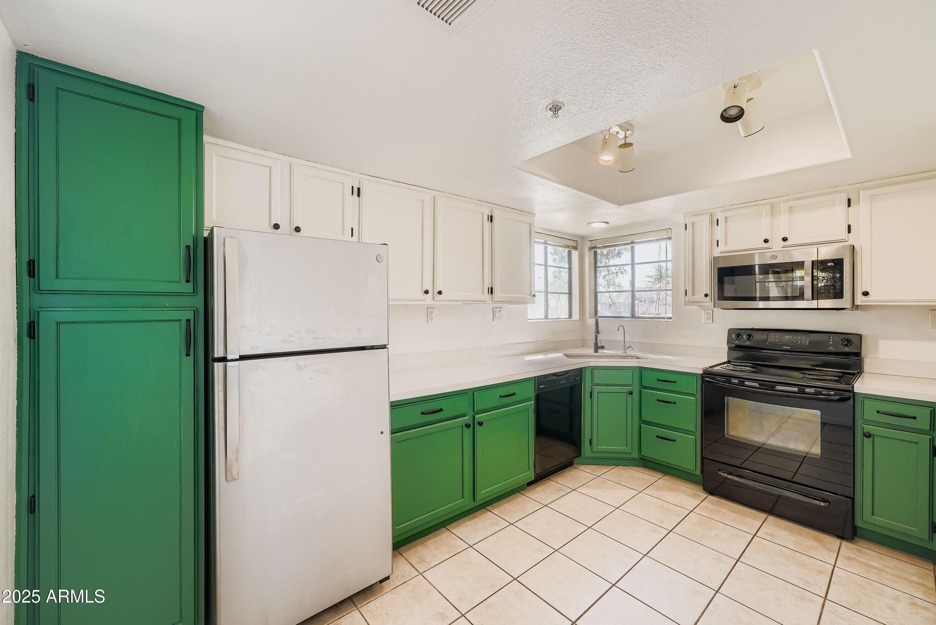 6885 East Cochise Road, Unit 105 Paradise Valley, AZ 85253 - Photo 3 of 11 a kitchen with cabinets a refrigerator and a stove top oven