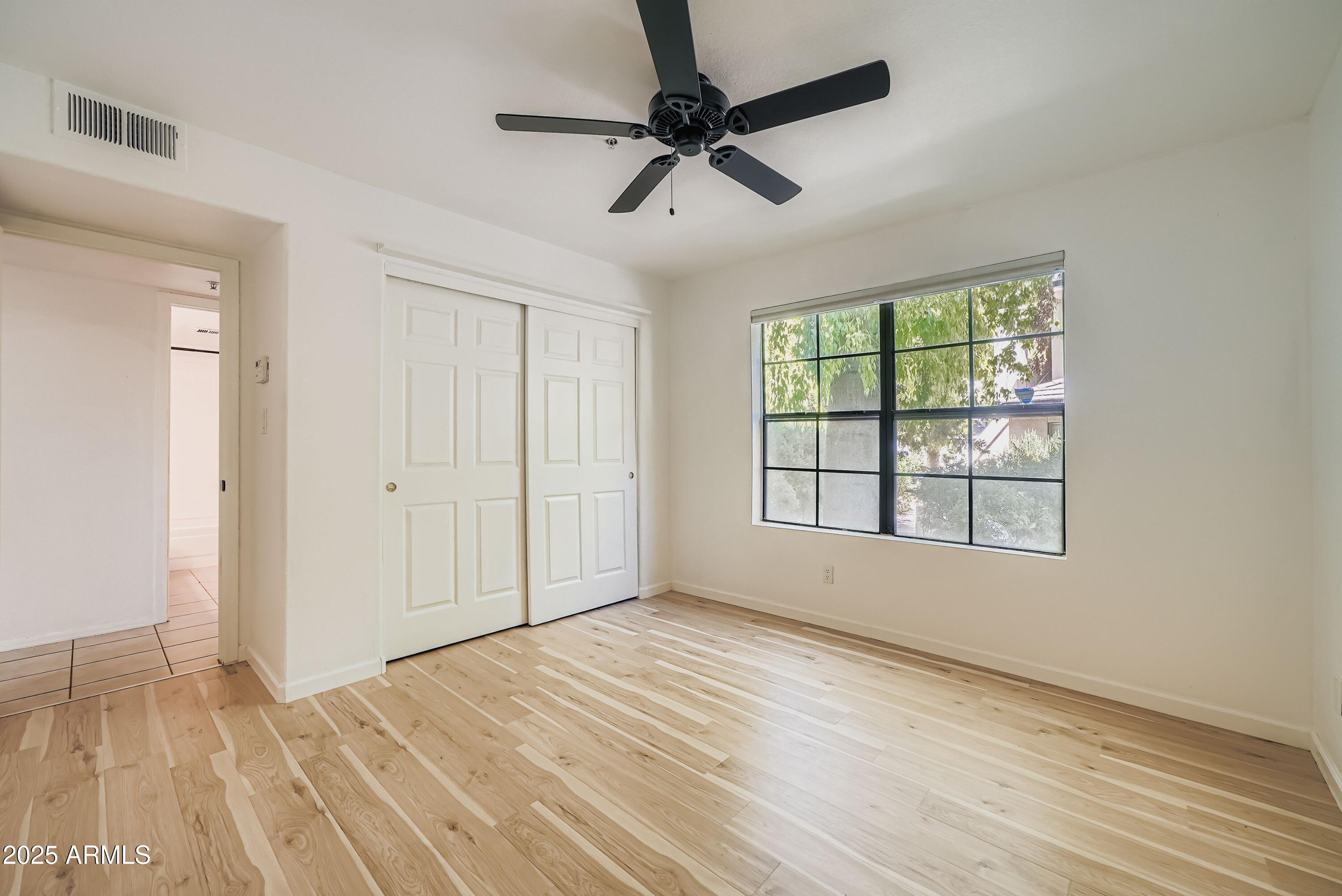6885 East Cochise Road, Unit 105 Paradise Valley, AZ 85253 - Photo 8 of 11 a view of empty room with wooden floor and fan