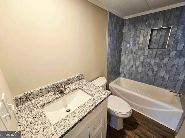 a bathroom with a granite countertop sink toilet and shower