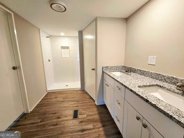 a bathroom with granite countertop shower and a sink