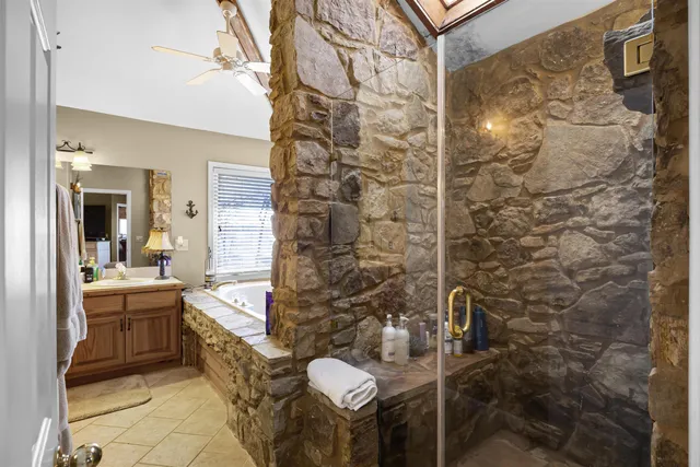 a spacious bathroom with a double vanity sink mirror and a bathtub with shower