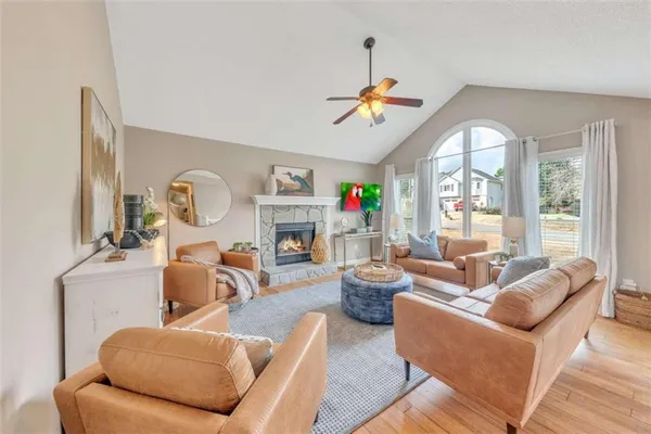 a living room with furniture fireplace and a large window