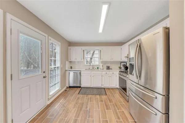 a kitchen with white cabinets and white appliances