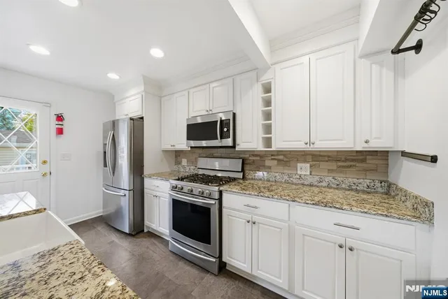 a kitchen with stainless steel appliances granite countertop a refrigerator sink and stove
