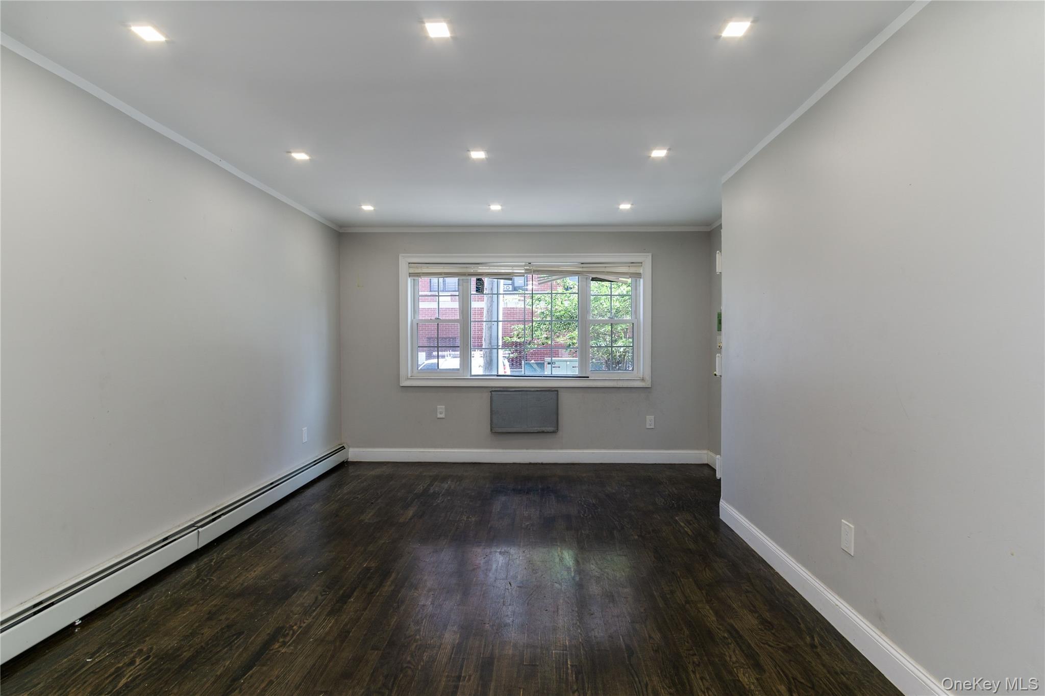2-15 Beach 96th Street Queens, NY 11693 - Photo 15 of 39 an empty room with wooden floor and windows