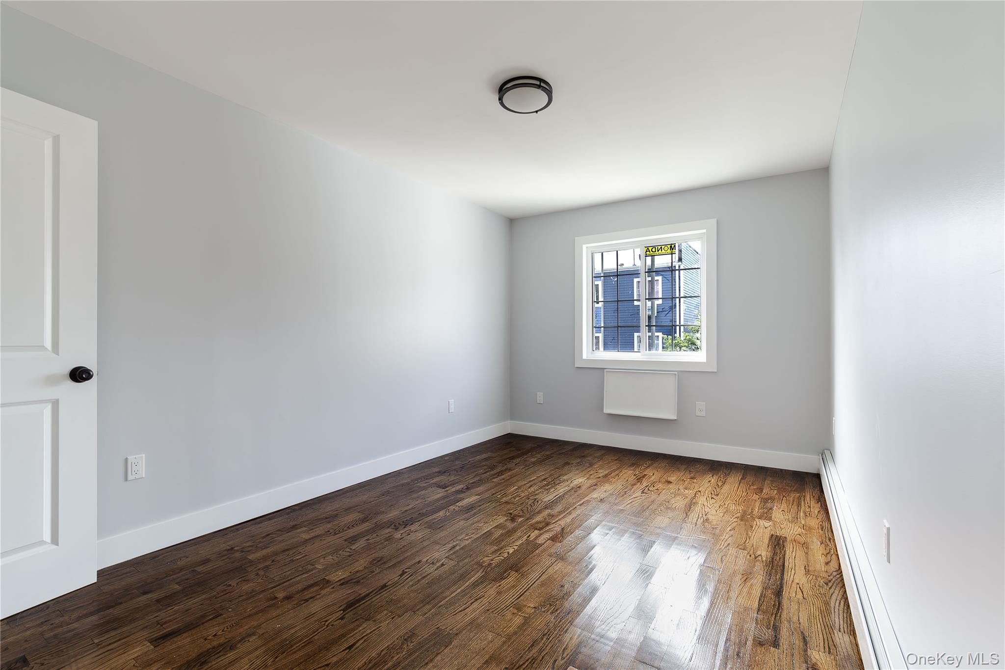2-15 Beach 96th Street Queens, NY 11693 - Photo 30 of 39 an empty room with wooden floor and windows