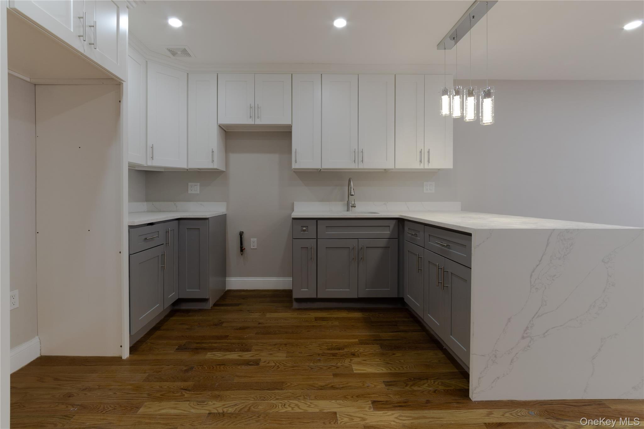 2-15 Beach 96th Street Queens, NY 11693 - Photo 7 of 39 a kitchen with cabinets and wooden floor