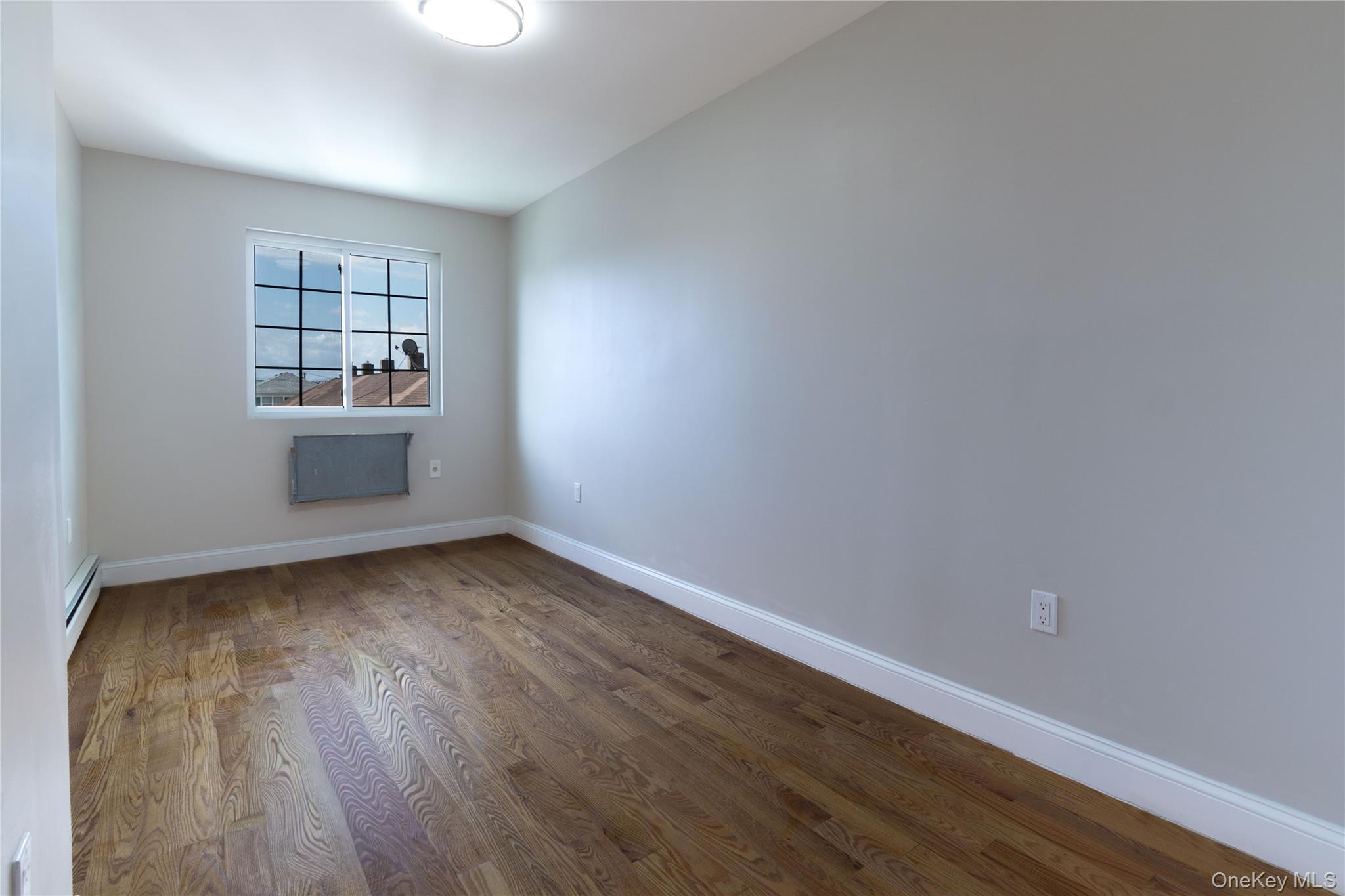 2-15 Beach 96th Street Queens, NY 11693 - Photo 10 of 39 a view of an empty room with wooden floor and a window
