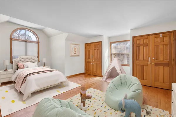 a bedroom with a large bed and wooden floor