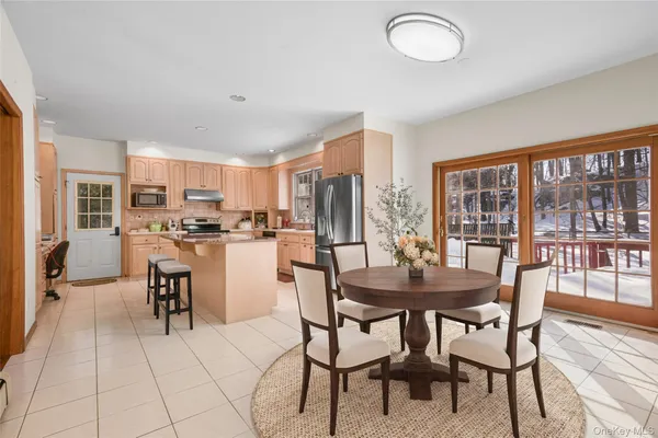 a dining room with stainless steel appliances granite countertop a table and chairs