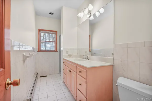 a bathroom with a double vanity sink a toilet and a mirror