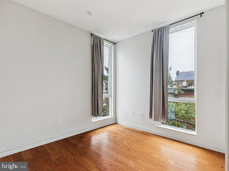 820 East Thompson Street, Unit E Philadelphia, PA 19125 - Photo 11 of 14 an empty room with wooden floor and windows