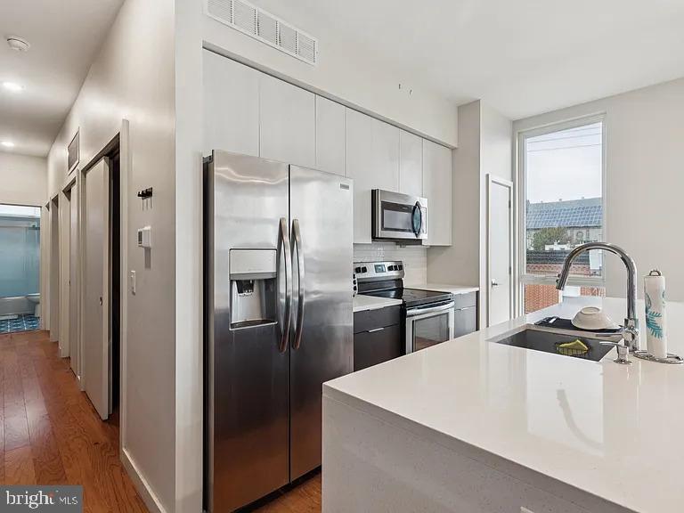 820 East Thompson Street, Unit E Philadelphia, PA 19125 - Photo 4 of 14 a kitchen with stainless steel appliances a refrigerator stove and sink