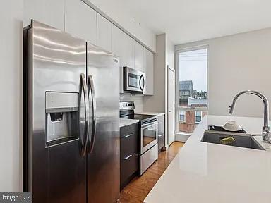 820 East Thompson Street, Unit E Philadelphia, PA 19125 - Photo 5 of 14 a kitchen with stainless steel appliances granite countertop a refrigerator and a stove