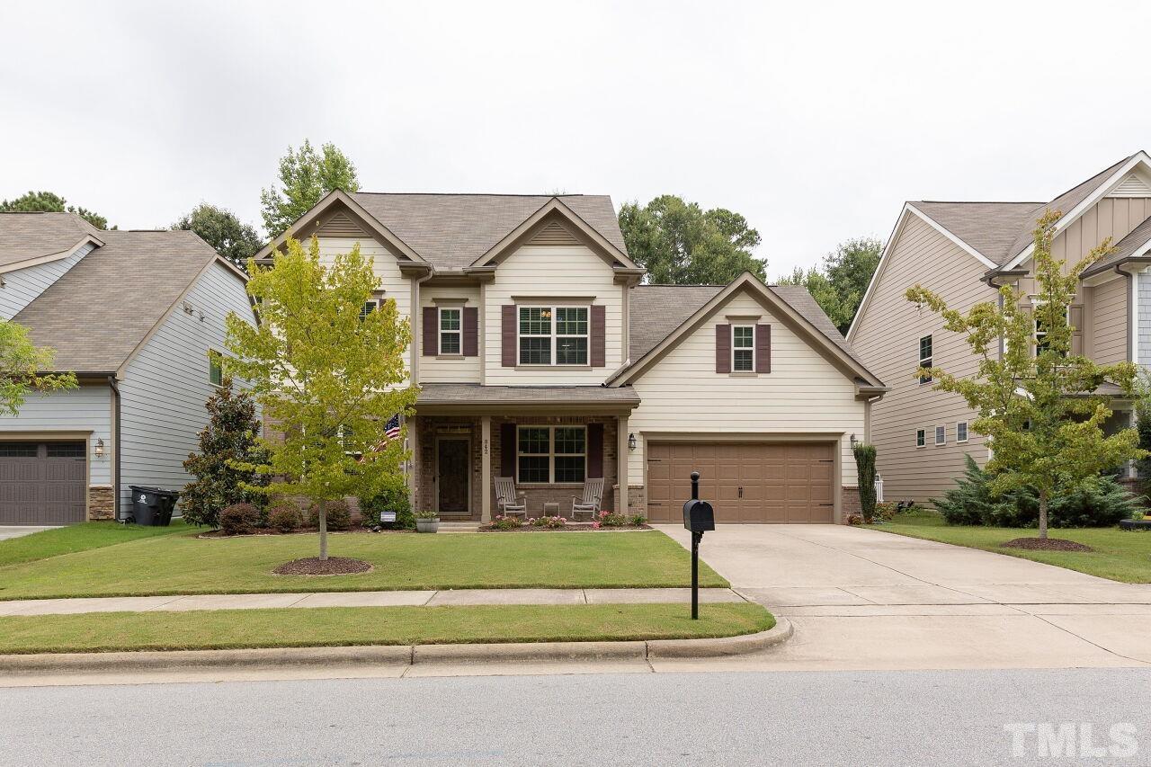 a front view of a house with a small yard and plants