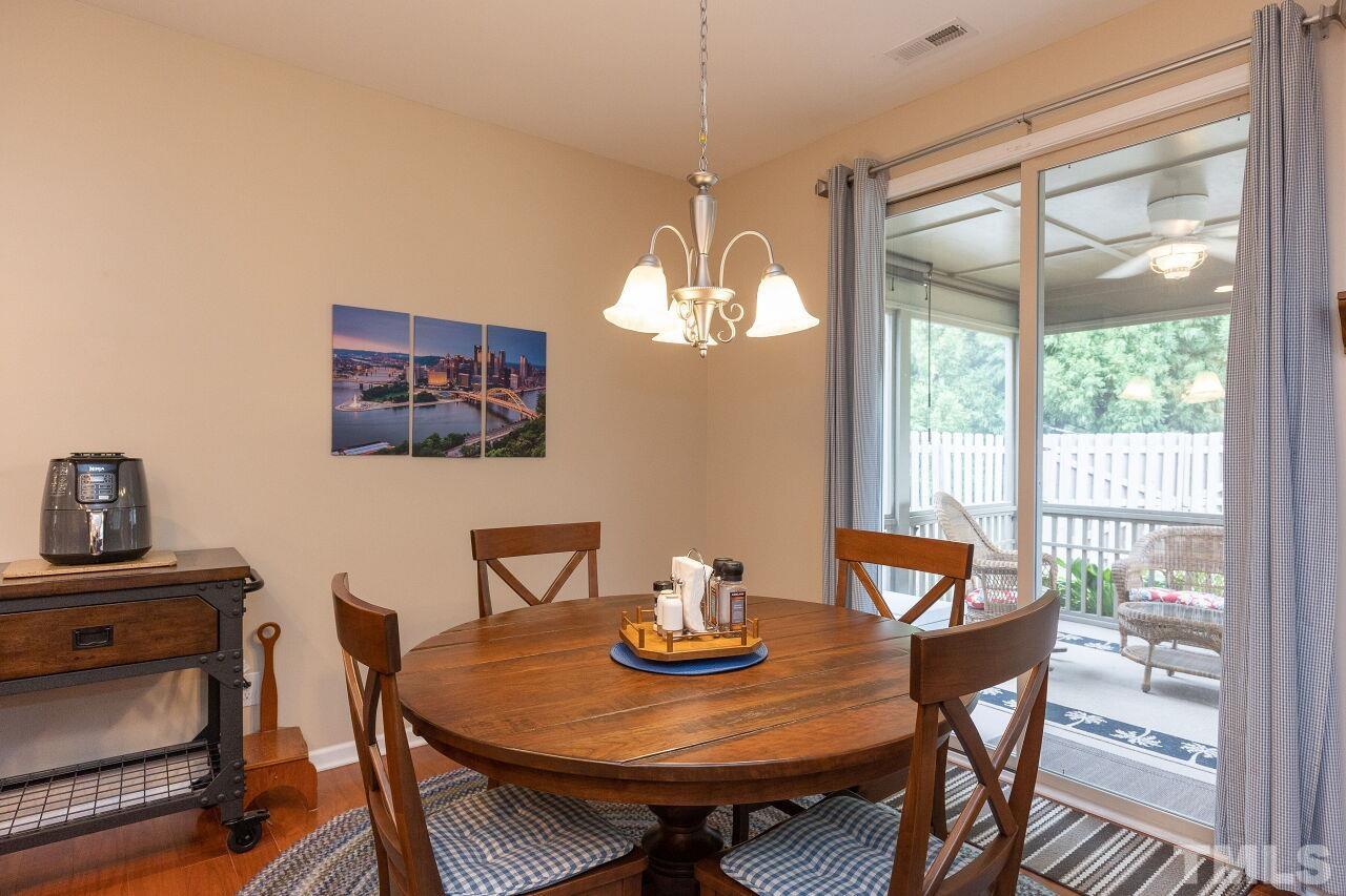 842 Wickham Ridge Road Apex, NC 27539 - Photo 14 of 43 a view of a dining room with furniture a chandelier and wooden floor