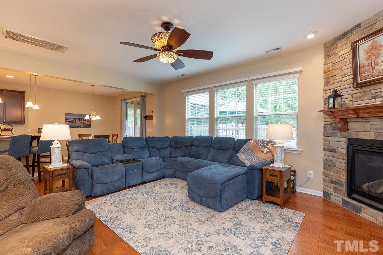 842 Wickham Ridge Road Apex, NC 27539 - Photo 16 of 43 a living room with furniture a fireplace and a flat screen tv