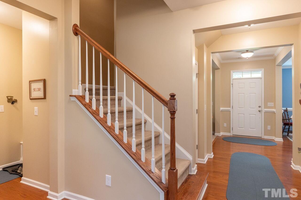 842 Wickham Ridge Road Apex, NC 27539 - Photo 20 of 43 a view of a hallway with wooden floor and staircase
