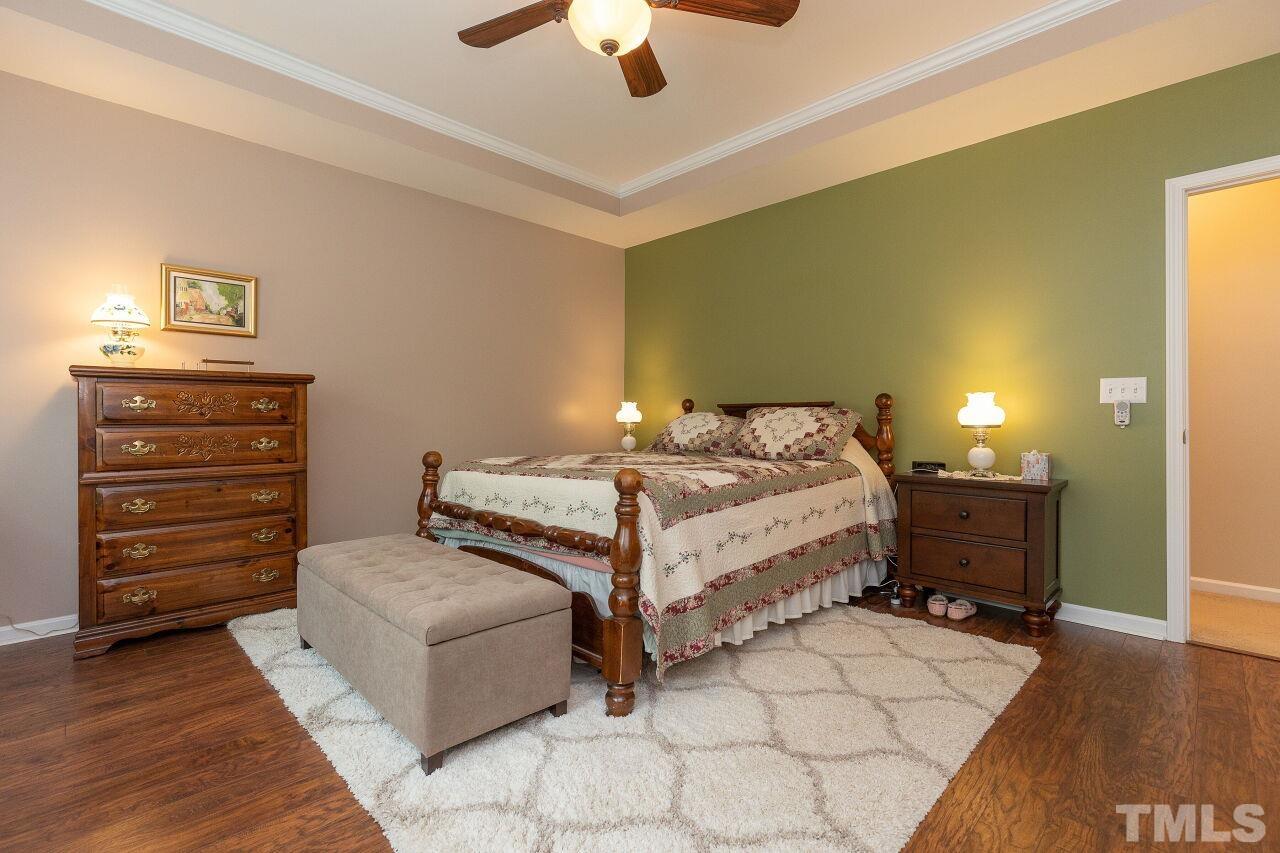 842 Wickham Ridge Road Apex, NC 27539 - Photo 23 of 43 a bedroom with a bed and a chandelier