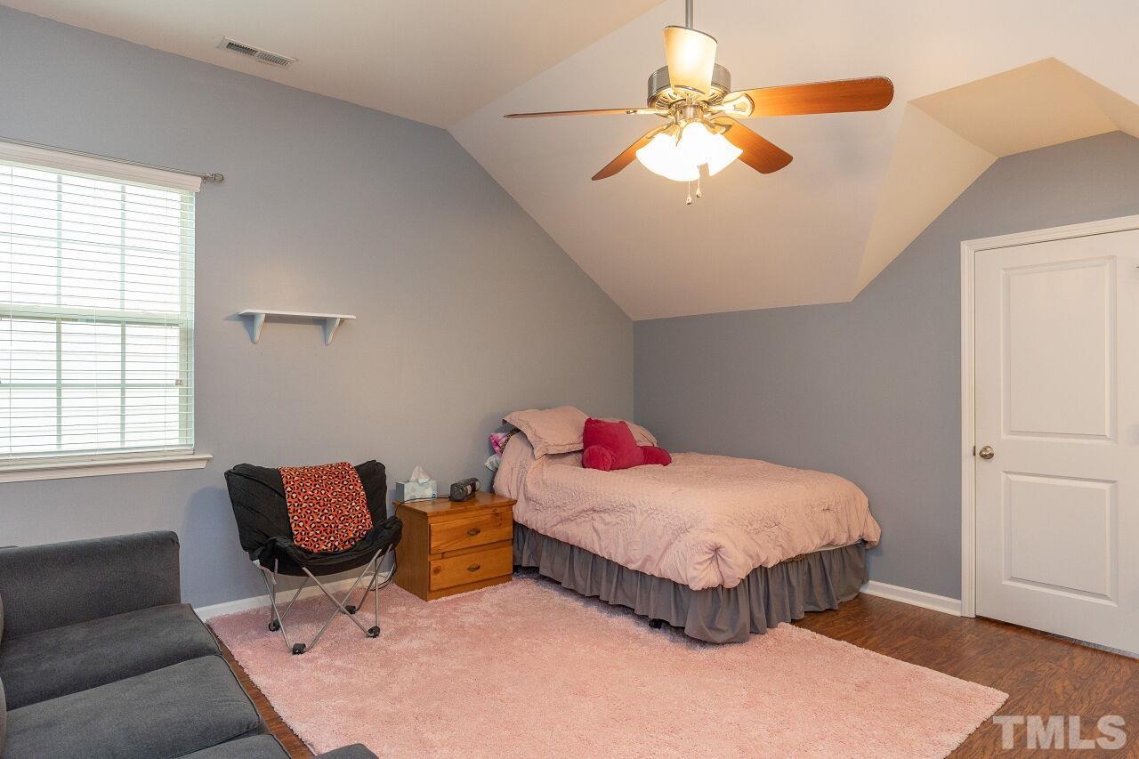 842 Wickham Ridge Road Apex, NC 27539 - Photo 26 of 43 a bedroom with a bed and a chandelier