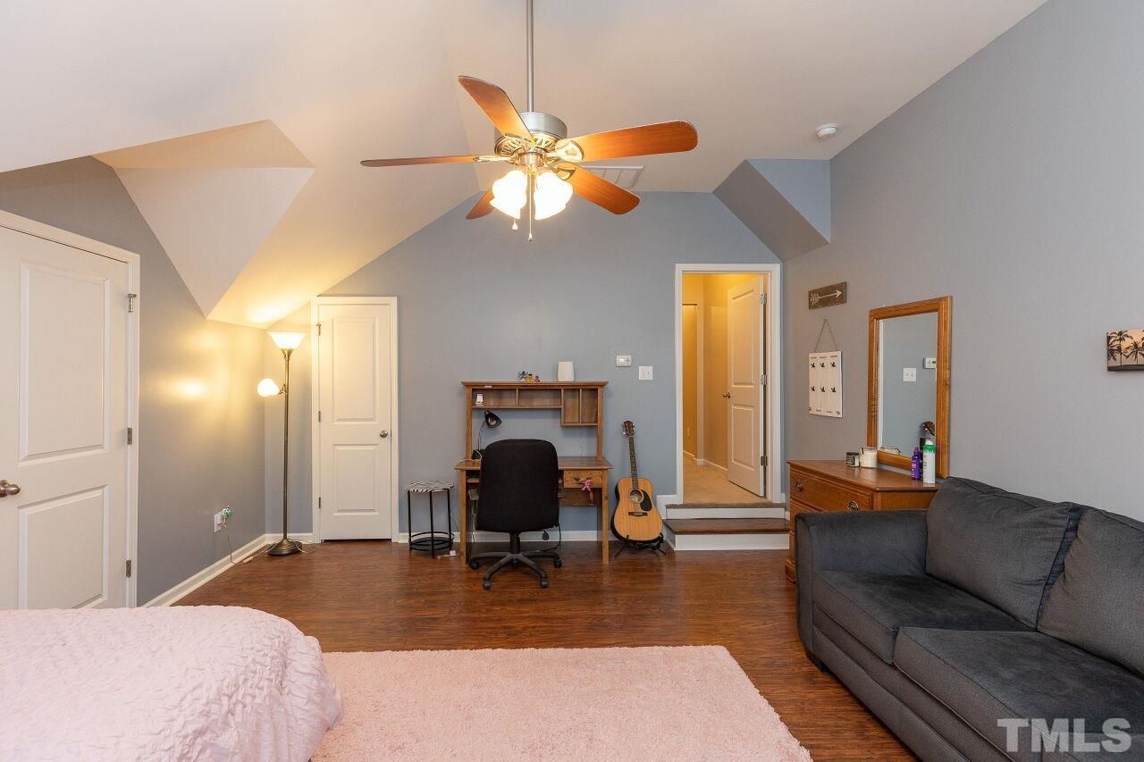 842 Wickham Ridge Road Apex, NC 27539 - Photo 27 of 43 a bedroom with a bed and a chandelier