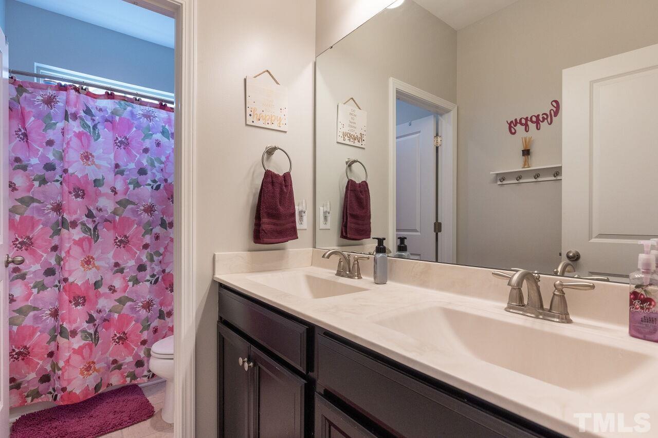 842 Wickham Ridge Road Apex, NC 27539 - Photo 31 of 43 a bathroom with a sink and a mirror
