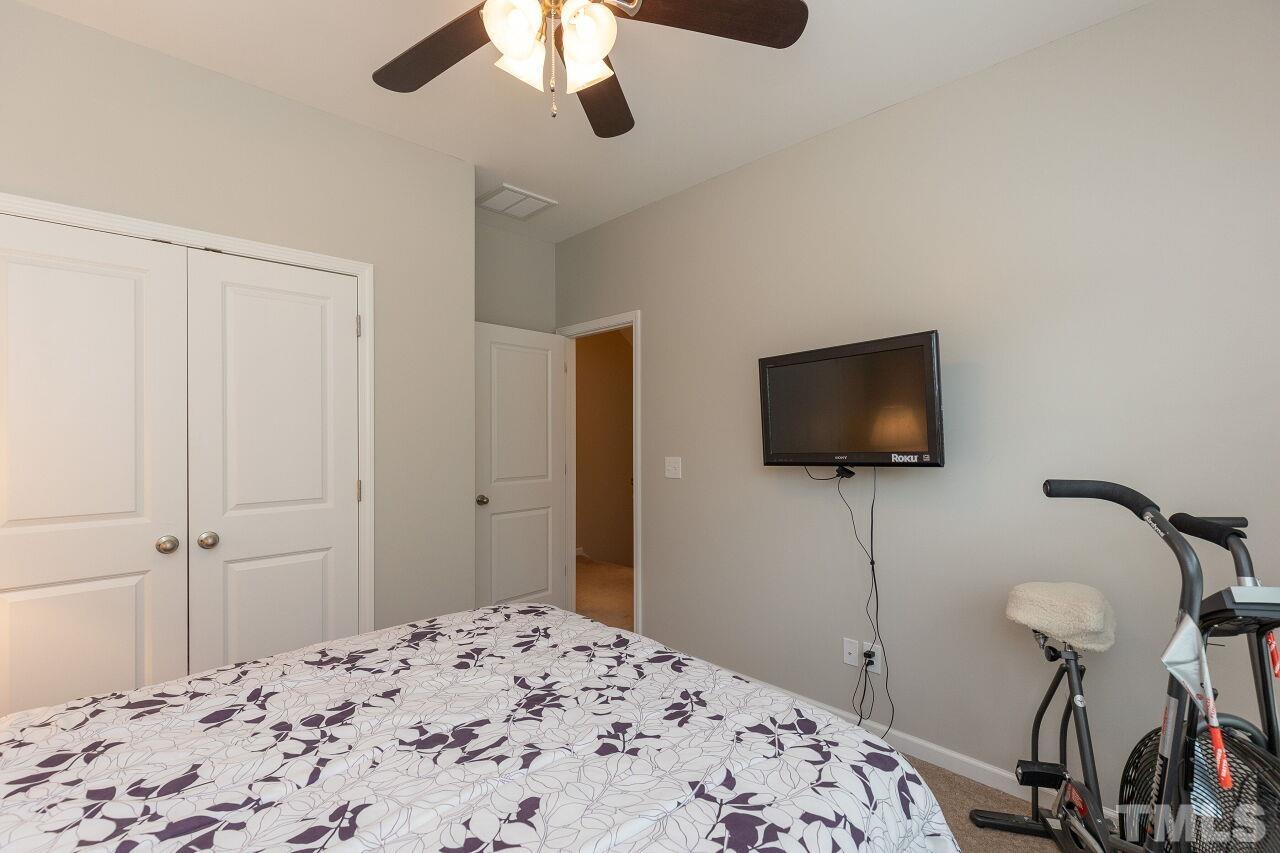842 Wickham Ridge Road Apex, NC 27539 - Photo 33 of 43 a bedroom with a bed and a flat screen tv