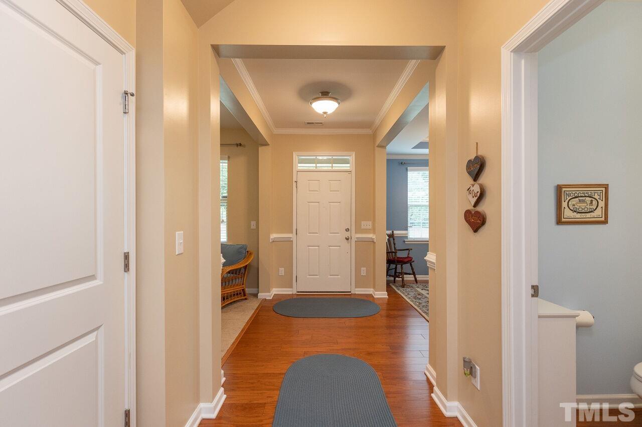 842 Wickham Ridge Road Apex, NC 27539 - Photo 5 of 43 a view of a hallway with wooden floor and staircase