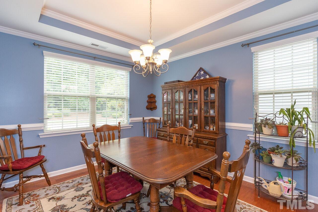 842 Wickham Ridge Road Apex, NC 27539 - Photo 7 of 43 a view of a dining room with furniture a chandelier and a window