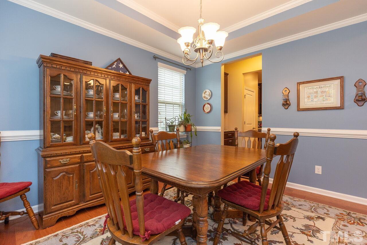 842 Wickham Ridge Road Apex, NC 27539 - Photo 8 of 43 a view of a dining room with furniture and chandelier