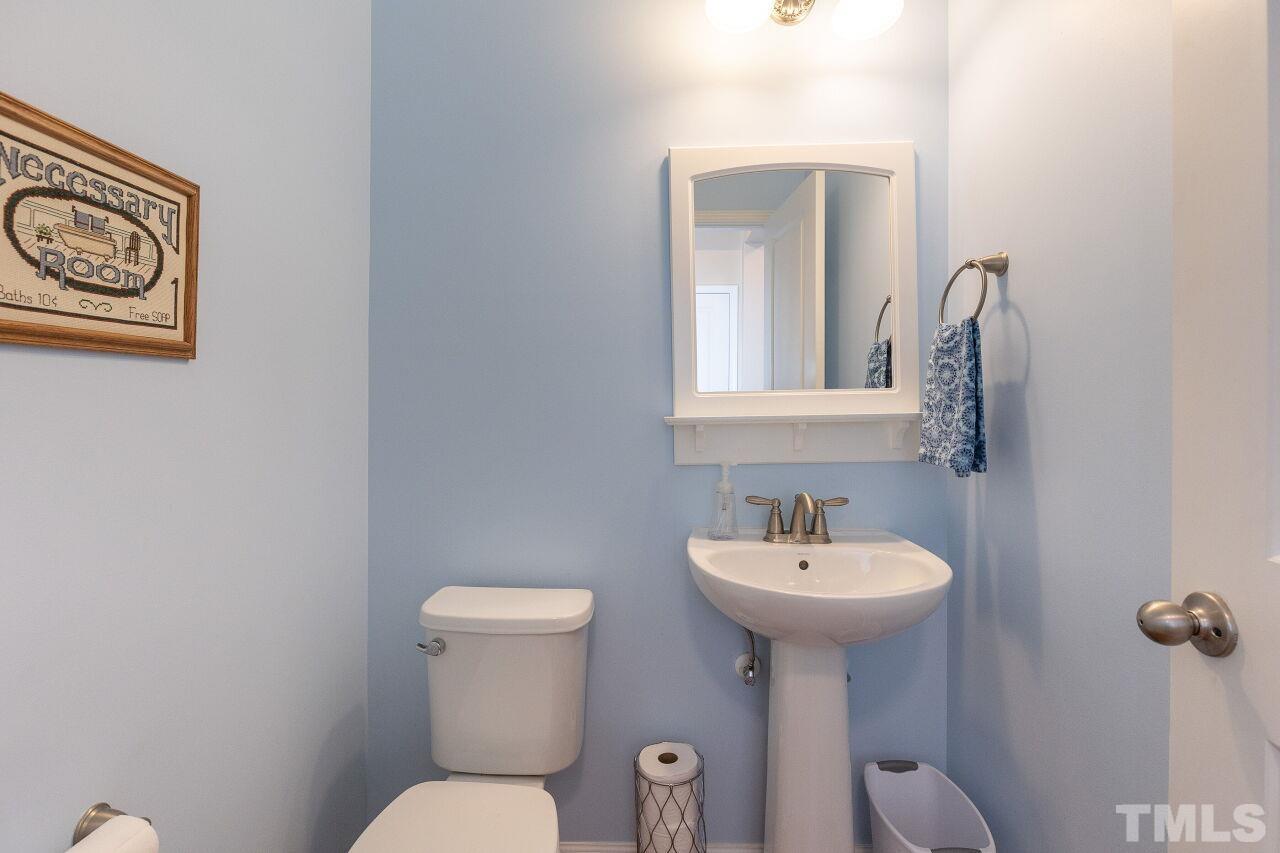 842 Wickham Ridge Road Apex, NC 27539 - Photo 9 of 43 a bathroom with a toilet sink and mirror