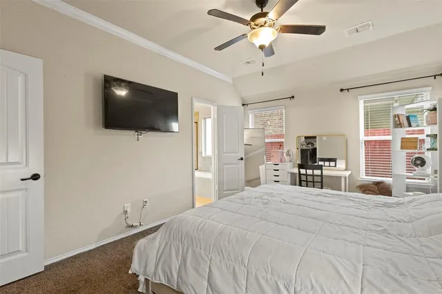 a bedroom with a bed a flat screen tv and a chandelier