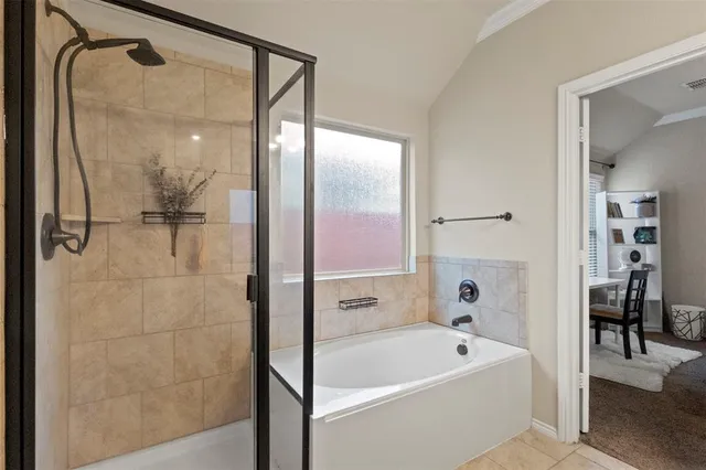 a bathroom with a tub a mirror and a shower