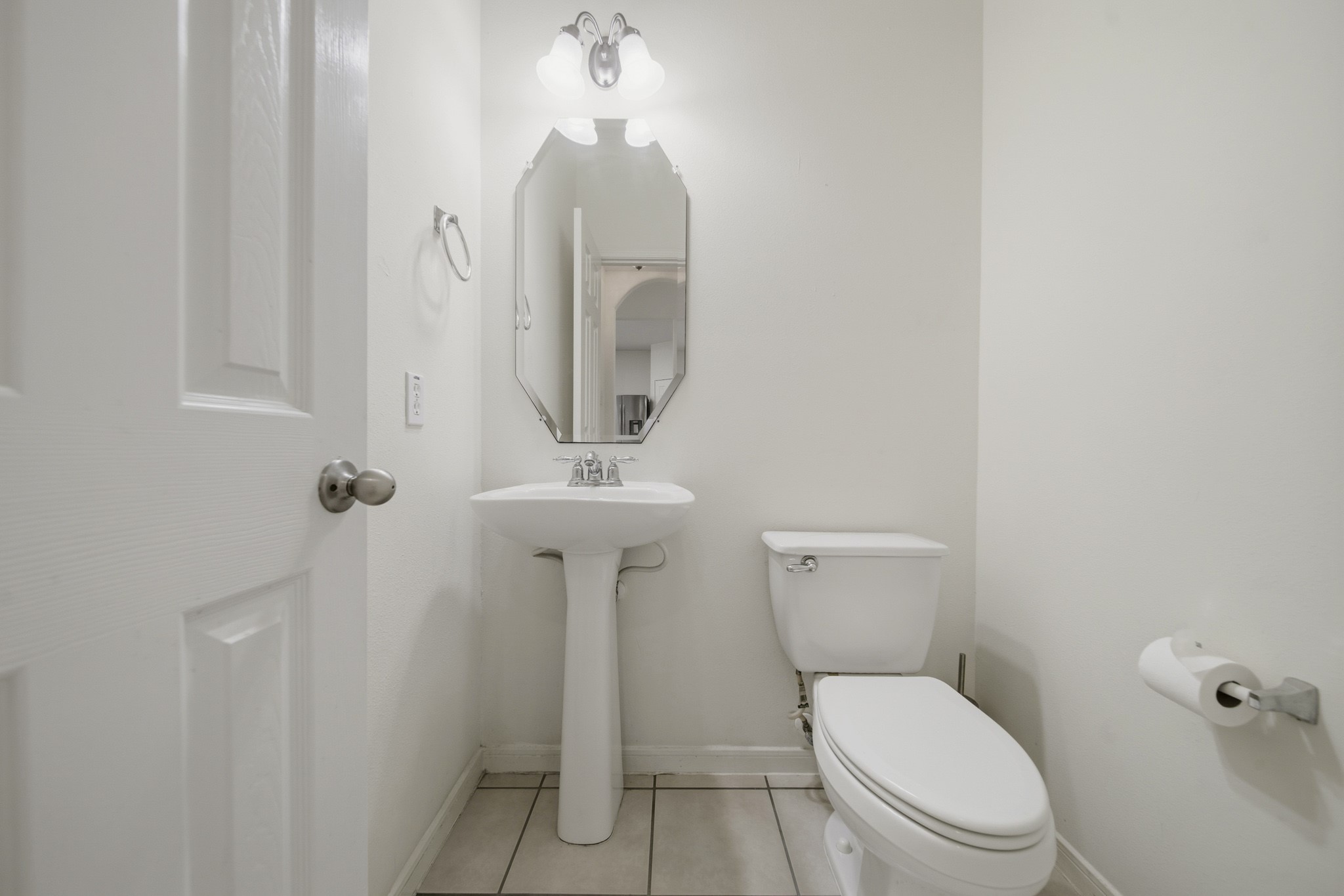 3306 Colleville Sur Mer Lane Spring, TX 77388 - Photo 20 of 30 This conveniently located half bath offers a clean and functional design, perfect for guests. Featuring a pedestal sink, decorative mirror, and bright vanity lighting, the space feels open and inviting.