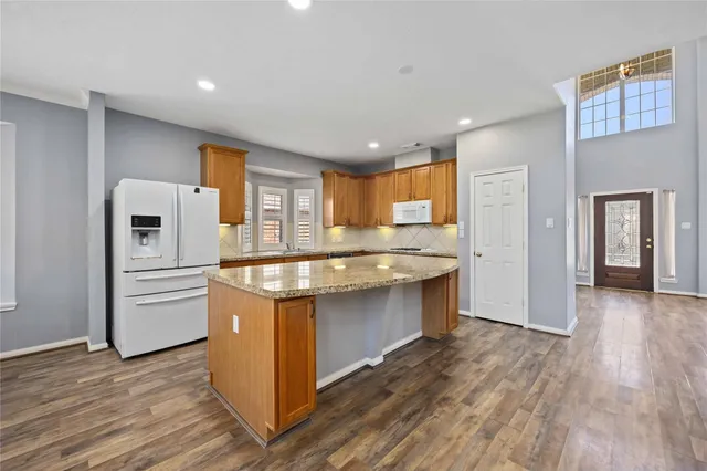 a kitchen with stainless steel appliances granite countertop a refrigerator and a stove top oven