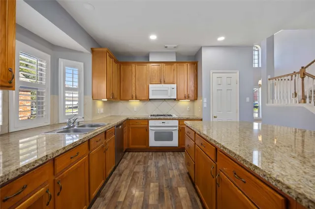 a kitchen with stainless steel appliances granite countertop sink stove top oven and cabinets