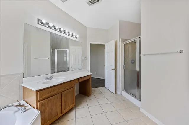 a spacious bathroom with a double vanity sink a mirror and a bathtub
