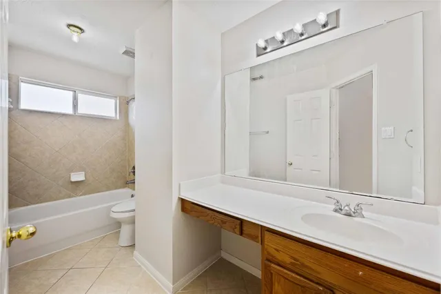 a bathroom with a sink a toilet and a large mirror