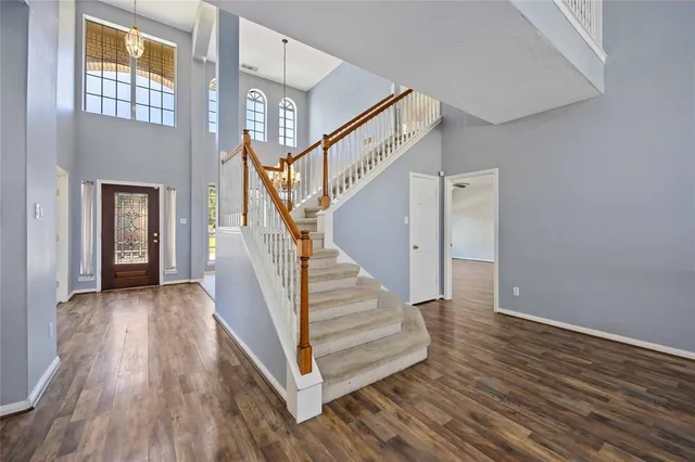 a view of a hallway with wooden floor and staircase