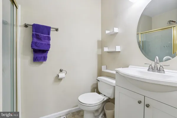 a bathroom with a toilet sink vanity and mirror