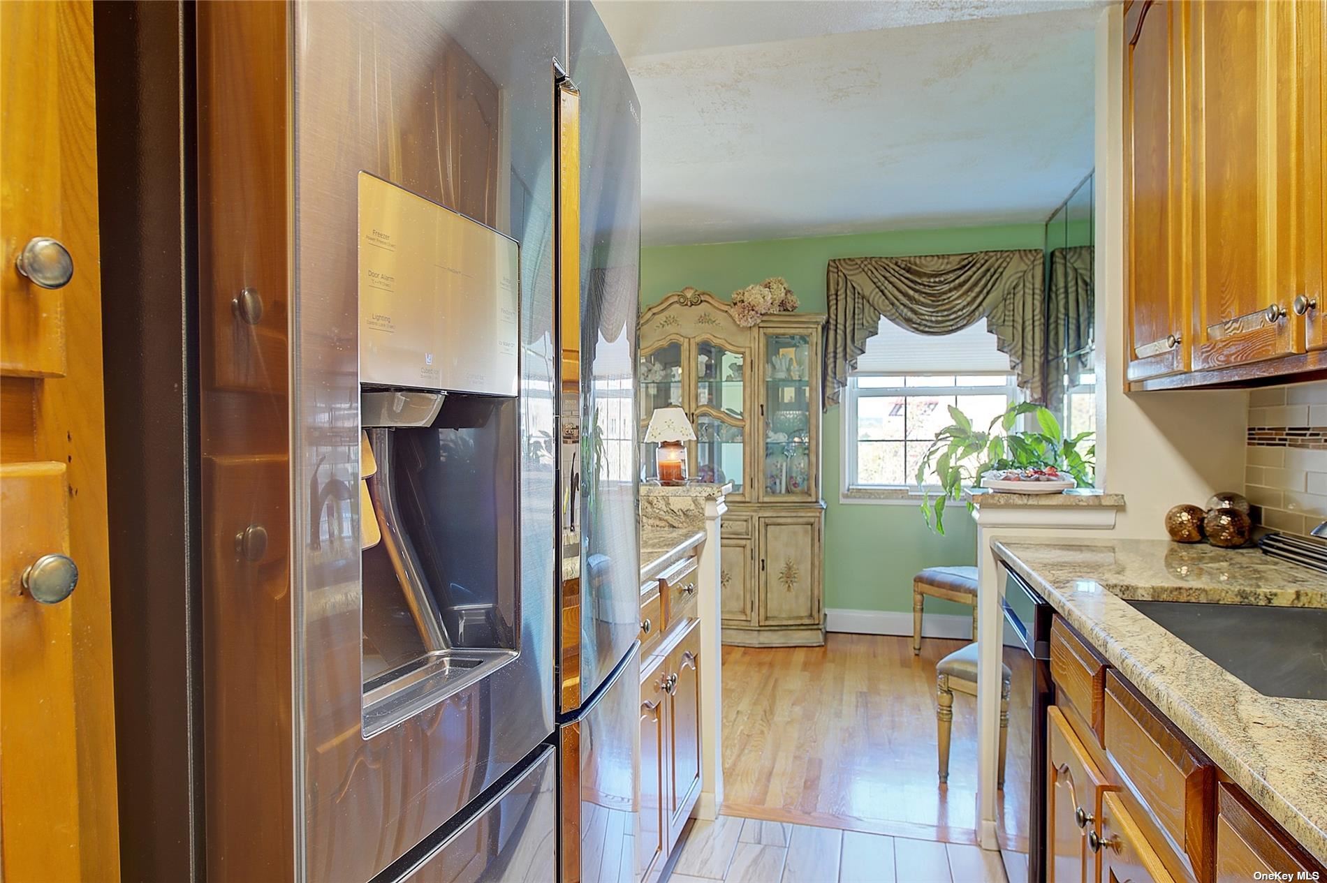 a kitchen with kitchen island granite countertop a sink and a refrigerator