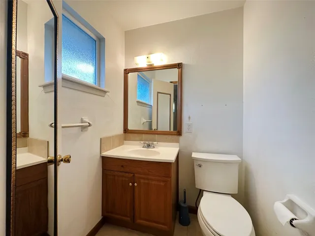 a bathroom with a toilet a sink and mirror