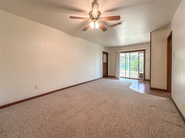 a view of a livingroom with a ceiling fan and window