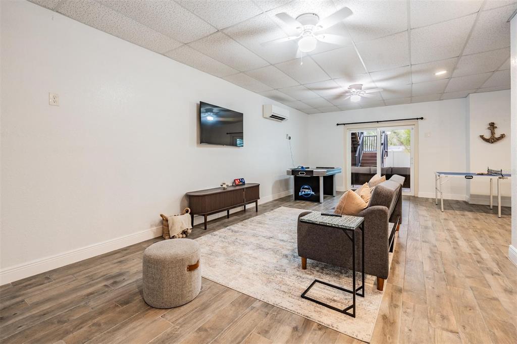 118 10th Avenue North Indian Rocks Beach, FL 33785 - Photo 22 of 31 a living room with furniture a flat screen tv and a wooden floor