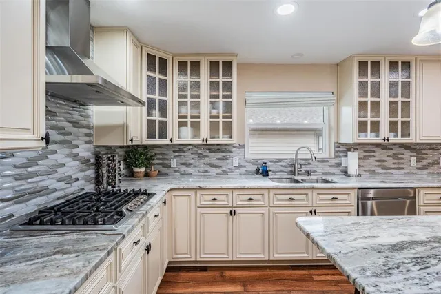 a kitchen with granite countertop a sink stove and cabinets