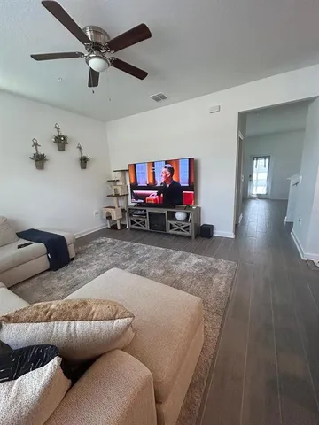 a living room with furniture and a wooden floor
